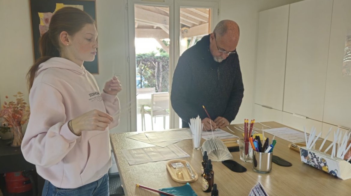 Deux participants concentrés, touches à sentir en main, dans l'atelier lumineux